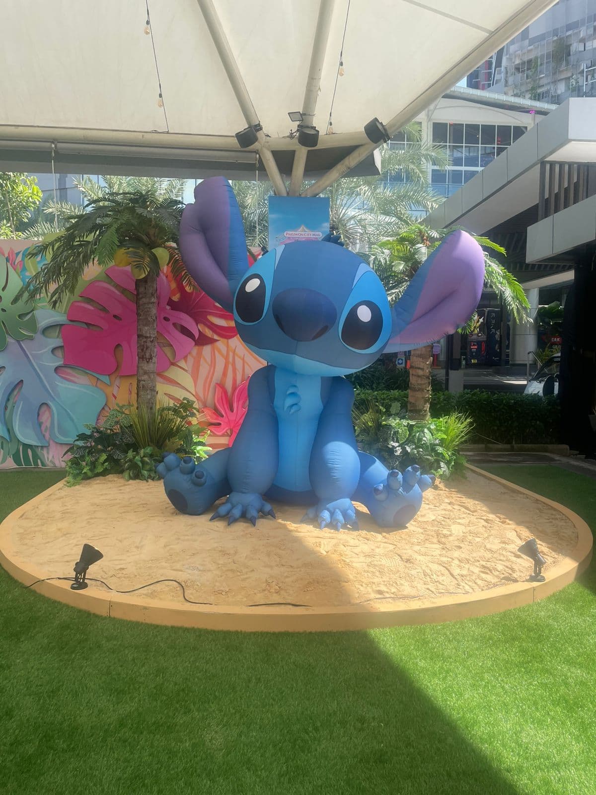 Inflatable Stitch berukuran besar dalam posisi duduk di atas pajangan pasir di Pakuwon City Mall, Indonesia
