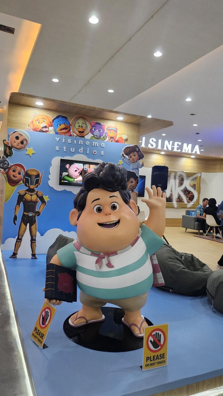 Patung Don dari film animasi Jumbo, dibuat untuk Visinema Studios, melambai sambil memegang buku di stan pameran studio